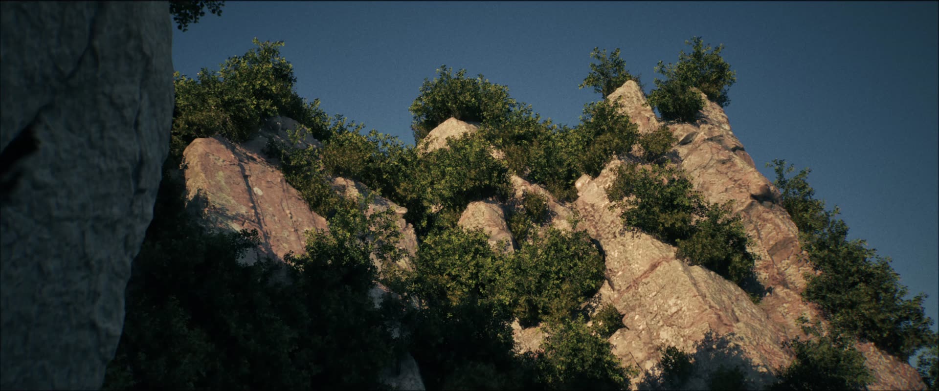 Limestone peaks covered in green scrub against a blue sky
