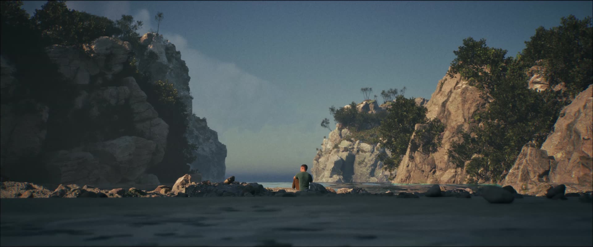 A figure on a beach between two cliffs